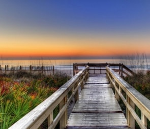 A boardwalk leading to the sea with orange sunset for the 'Southeast' catagory selection.